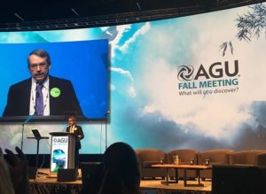 A photo of Eric Davidson, AGU President, standing at a podium with a screen behind him announcing "AGU 2017 Fall Meeting"